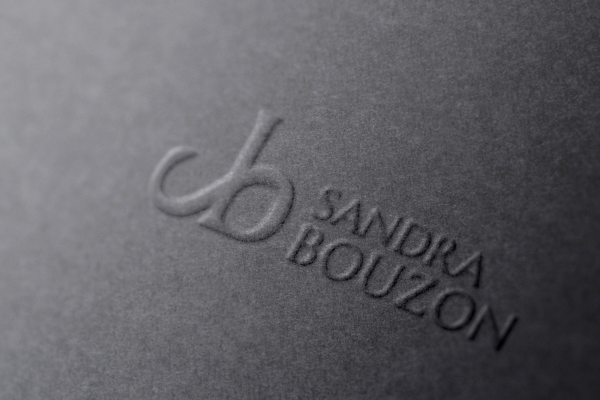 logo Sandra Bouzon gaufrage sur papier gris